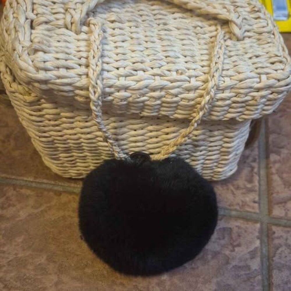 Beige woven straw crossbody bag with black fur pom-pom